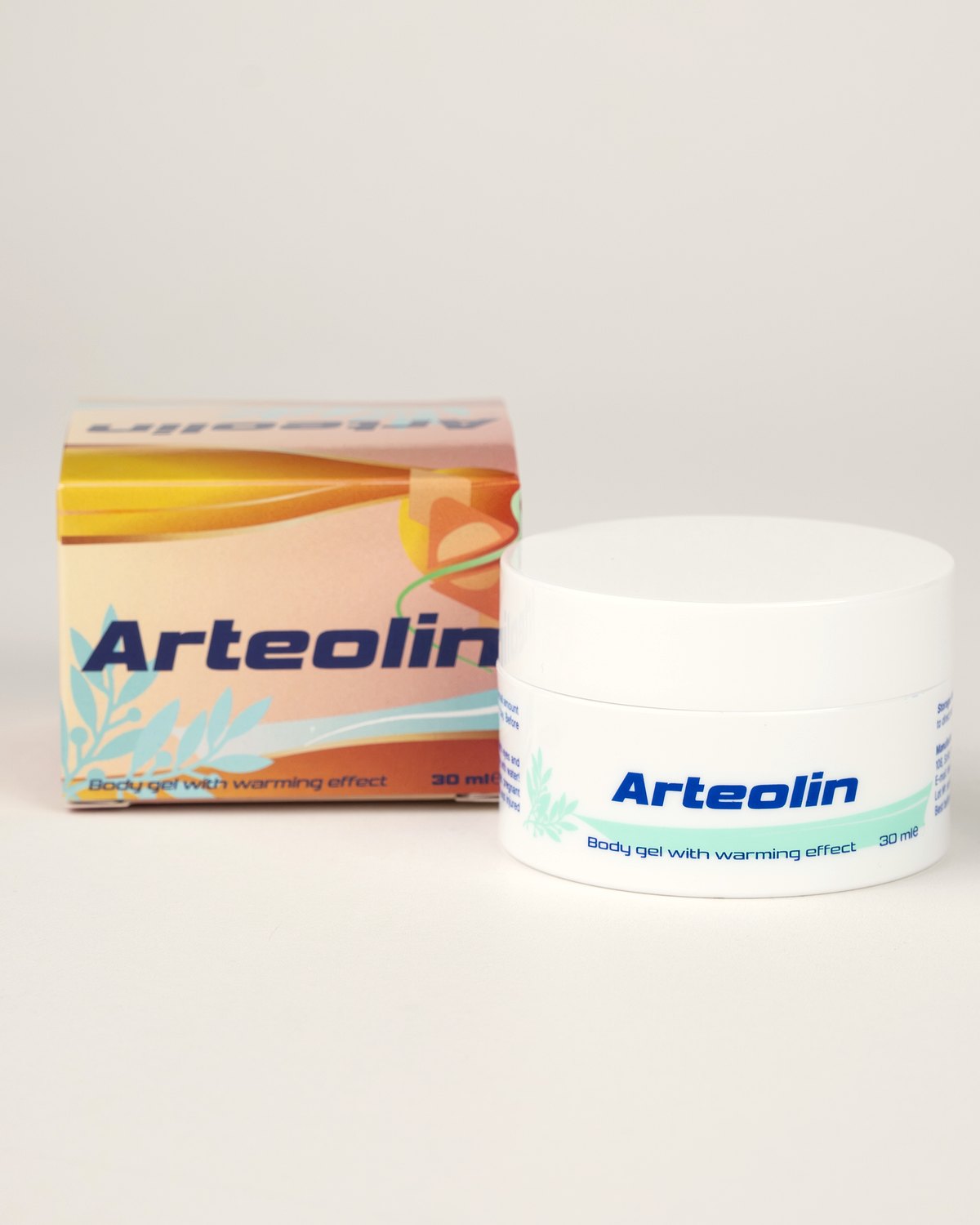 Arteolin melegítő testgél 30 ml-es fehér tégelye mentazöld címkével, mögötte a barackszínű doboz